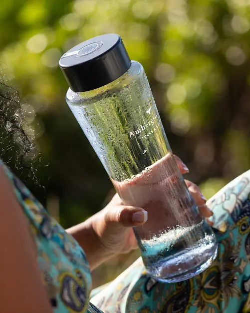Guest holding a chilled Ambergris Cay water bottle